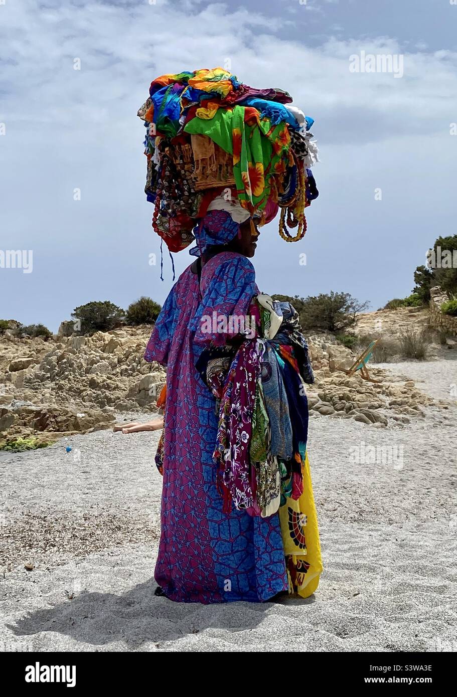 Beach Vendor, seller Carrying Vibrant Clothes on her head - Smartphone Captured Stock Image