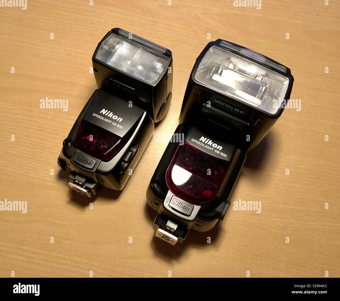 Two Nikon Speedlight flash units on wooden desk Stock Photo Alamy