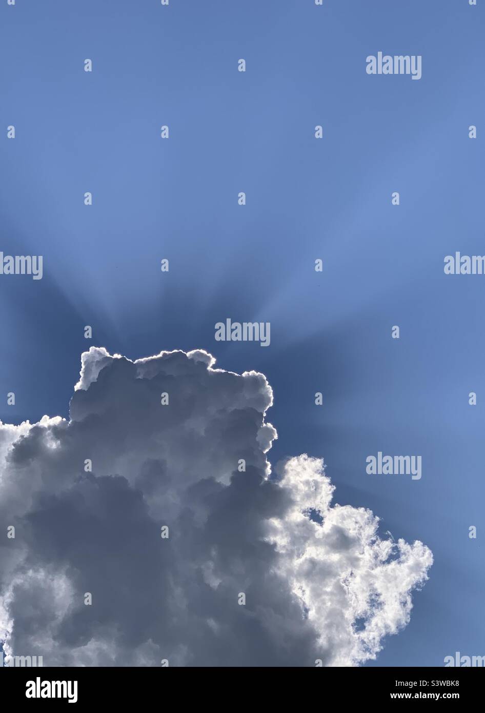 Clouds backlit by sunlight against a blue sky - Smartphone Captured Stock Image