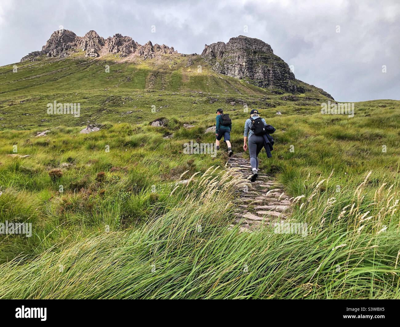 Walkers on the path approach to Stac Pollaidh or Stack Polly, viewed from the south, mountain in Inverpolly, North West Scotland - Smartphone Captured Stock Image