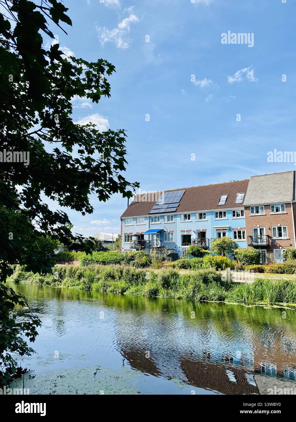 Row of riverside terraced houses reflected on the water below (spot the