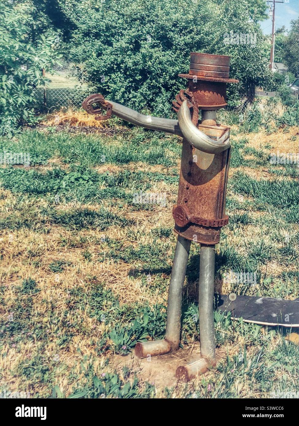 Tin man touching his nose, seen in a yard Stock Photo