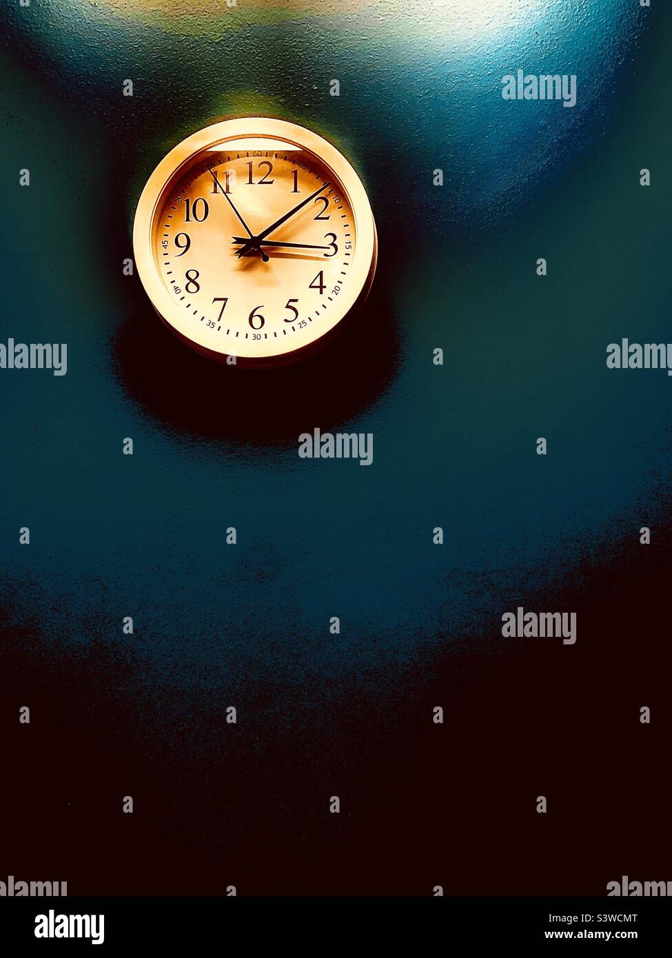 Clock on blank wall in dark room - Smartphone Captured Stock Image