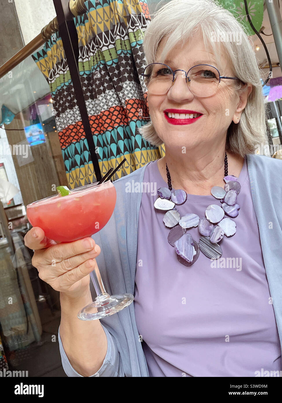 Senior woman enjoying a flavored margarita at an upscale Mexican