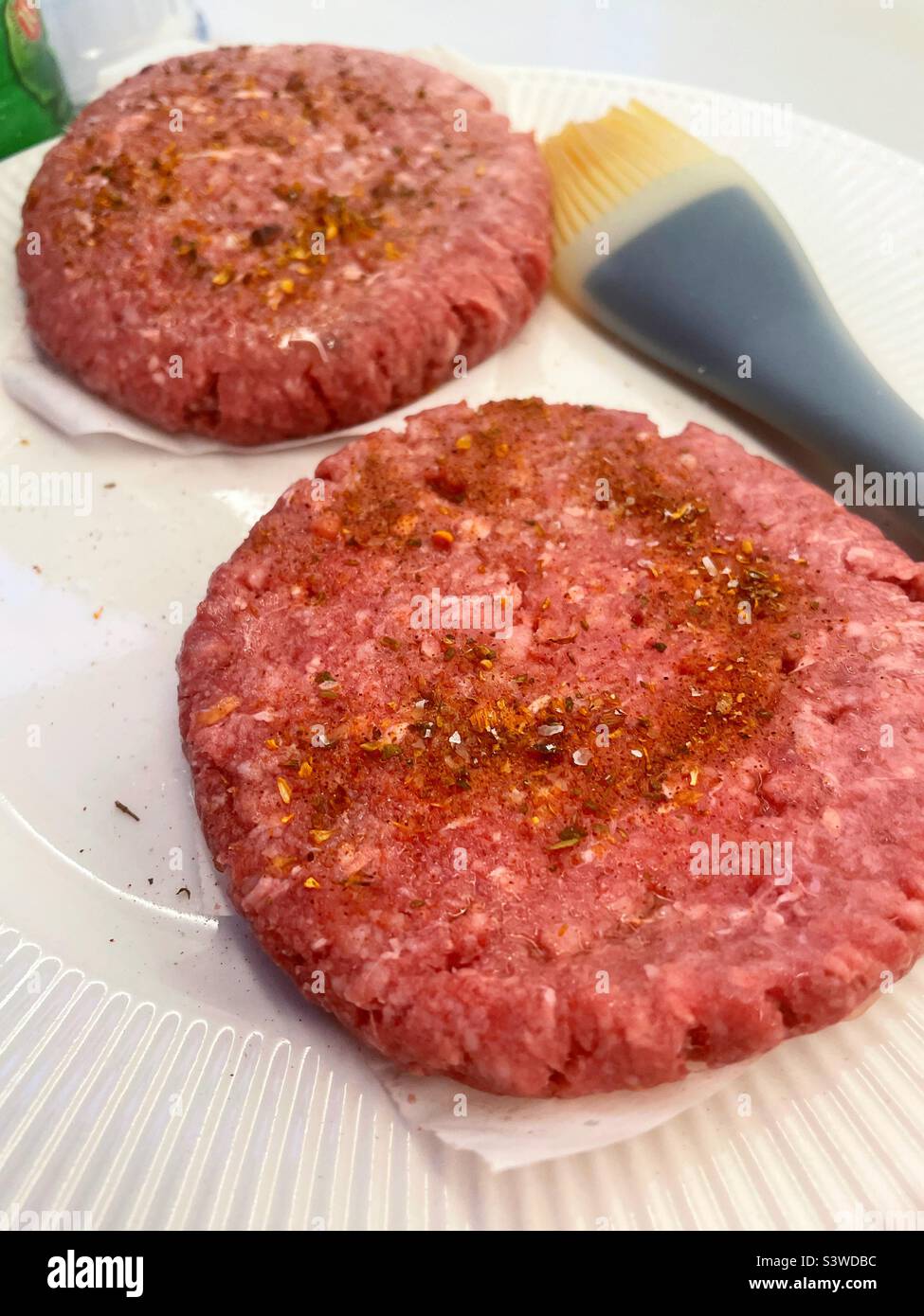 Raw Ground beef hamburger patties seasoned and ready to grill, 2022