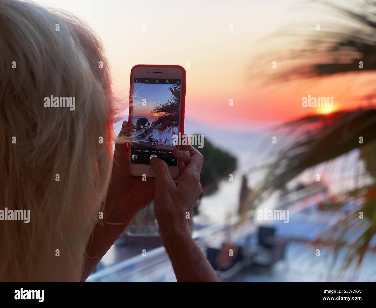 Taking a photo of beautiful tropical sunset - Smartphone Captured Stock Image