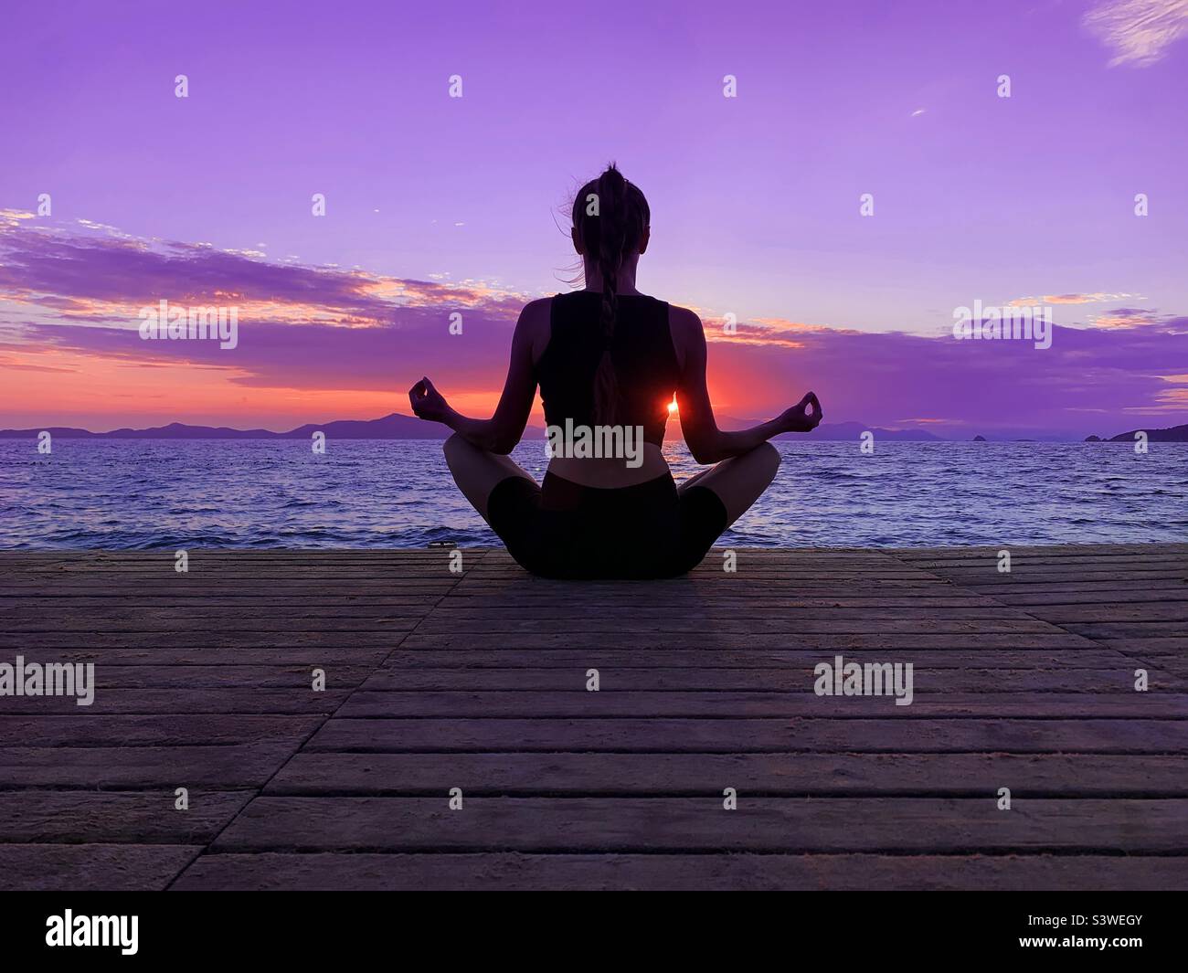 Young woman doing yoga outdoor at sunset - Smartphone Captured Stock Image