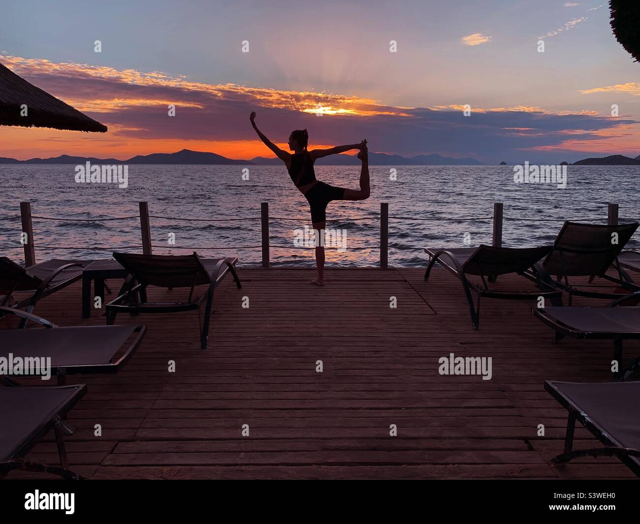 Young woman doing yoga outdoor at sunset - Smartphone Captured Stock Image