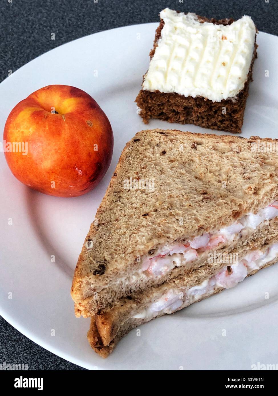 Prawn sandwich, carrot cake and nectarine for lunch - Smartphone Captured Stock Image