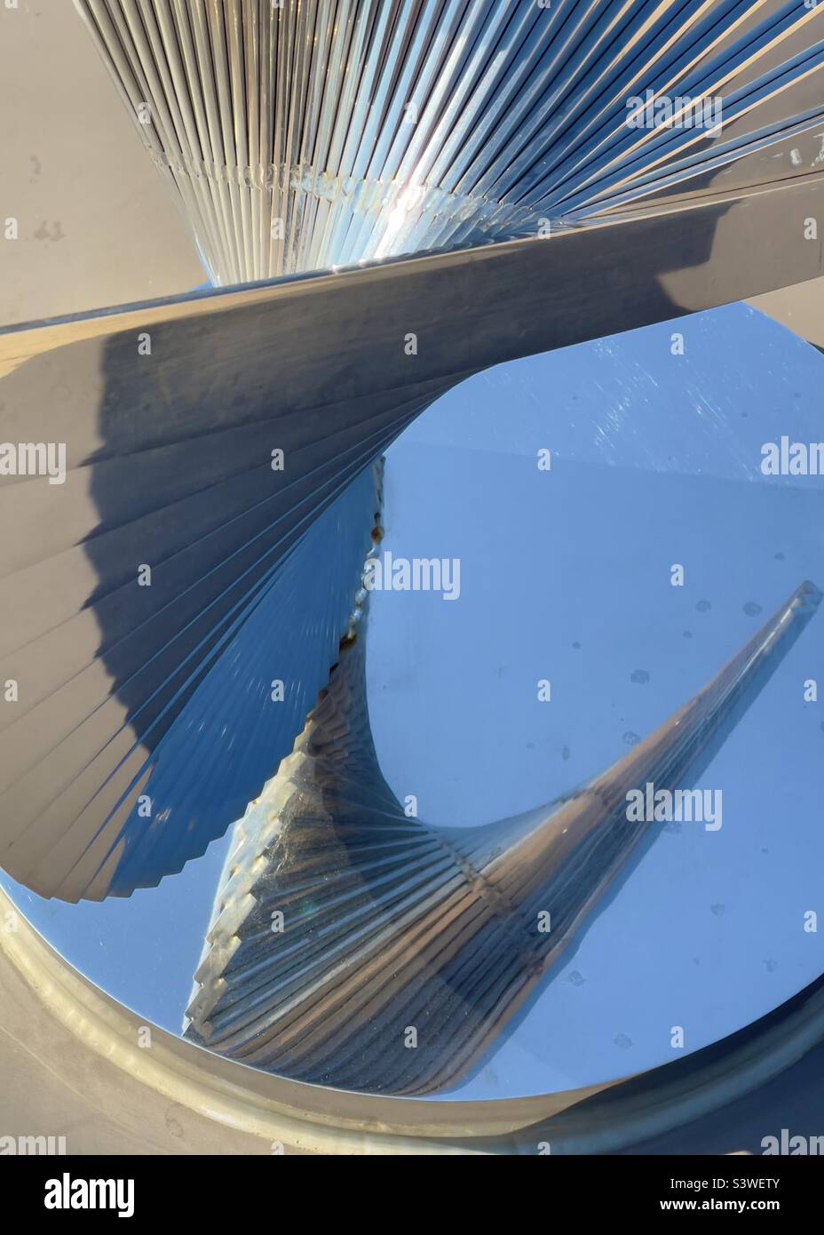 A silvery chrome plated sculpture reflected in its own base on board a cruise ship - Smartphone Captured Stock Image