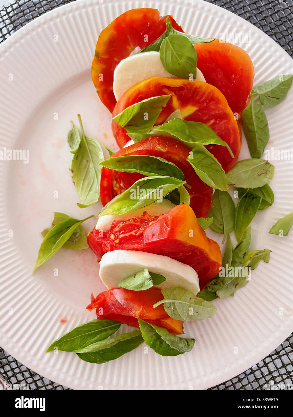 Healthy salad consisting of heirloom tomatoes, mozzarella cheese and
