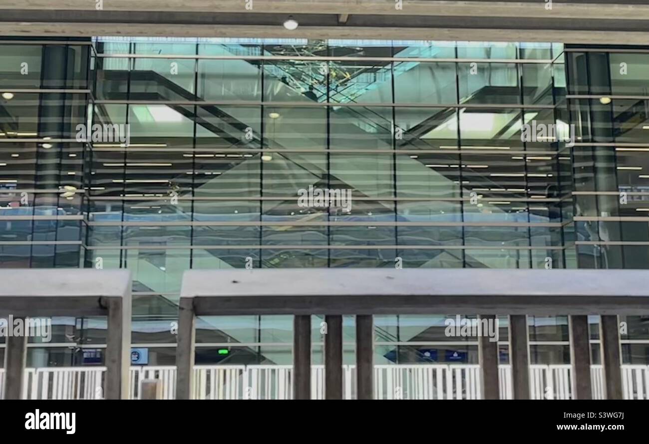 Taken from the passenger pickup area of the Salt Lake Intl Airport, this makes an interesting architectural abstract. In the center you can see crisscrossing escalators inside behind tinted glass. Stock Photo