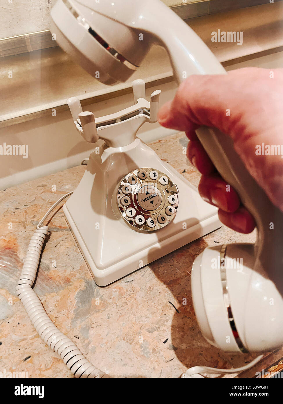 Man holding a receiver of a hotel house phone in the lobby of a Manhattan hotel, 2022, USA, New York City - Smartphone Captured Stock Image