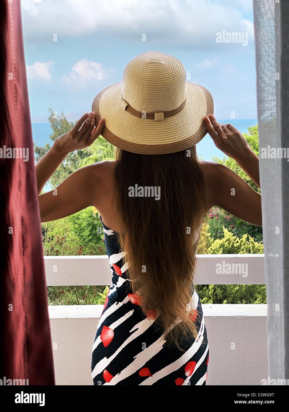 Young woman in summer clothes standing at the terrace - Smartphone Captured Stock Image