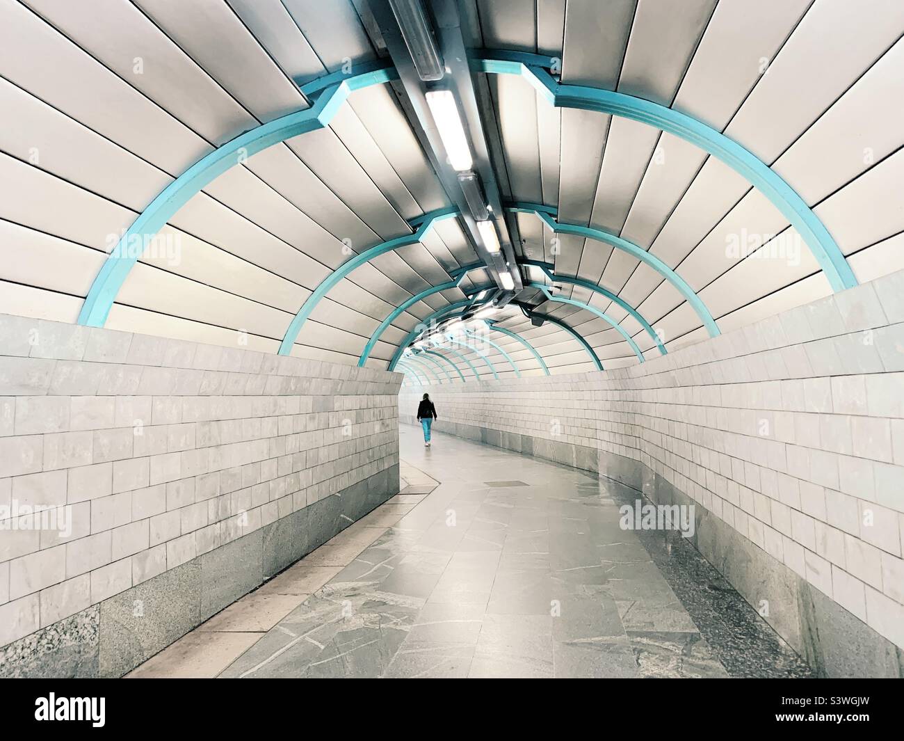 Tiny human walking by the geometric tunnel - Smartphone Captured Stock Image