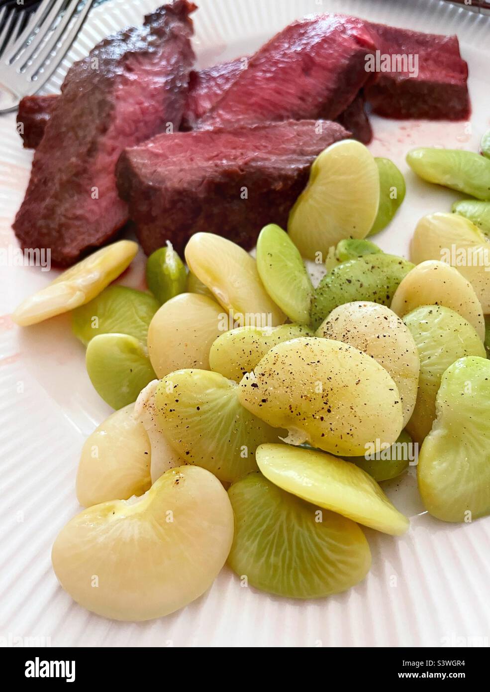 Close up of freshly steamed lima beans and grilled steak meal, 2022, USA - Smartphone Captured Stock Image