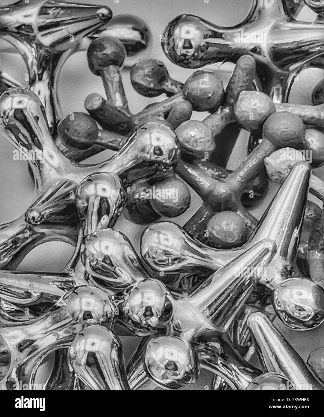 Miscellaneous jacks of varying sizes, colors and textures have been desaturated and given a glow effect. A nice artistic abstract focusing on shape, tone and texture, rather than color. Stock Photo