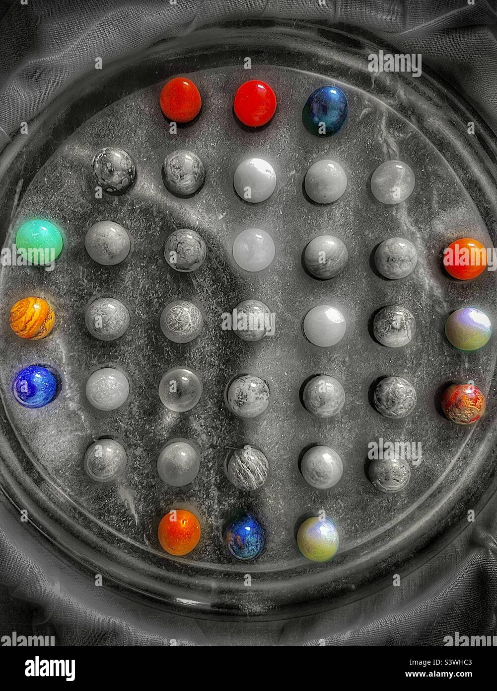 A beautiful onyx, stone marble Chinese Checker game set. Gorgeous textures and tones can be seen in the black and white image, highlighted by the patterned color select marble pieces. - Smartphone Captured Stock Image