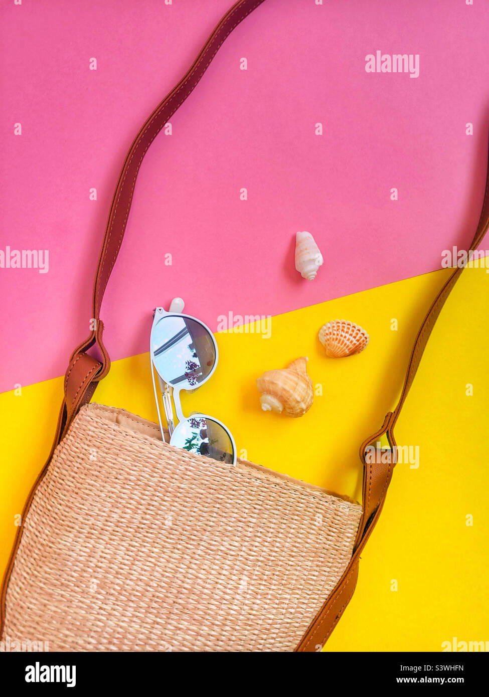 Summer bag with sunglasses and seashells, vacation time. Flatlay on colorful background. Stock Photo