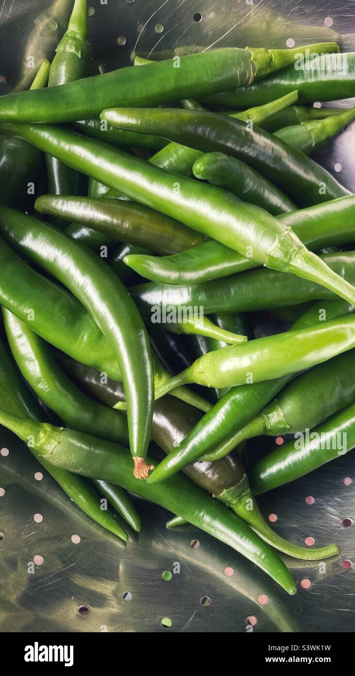 Green chili peppers in a strainer Stock Photo