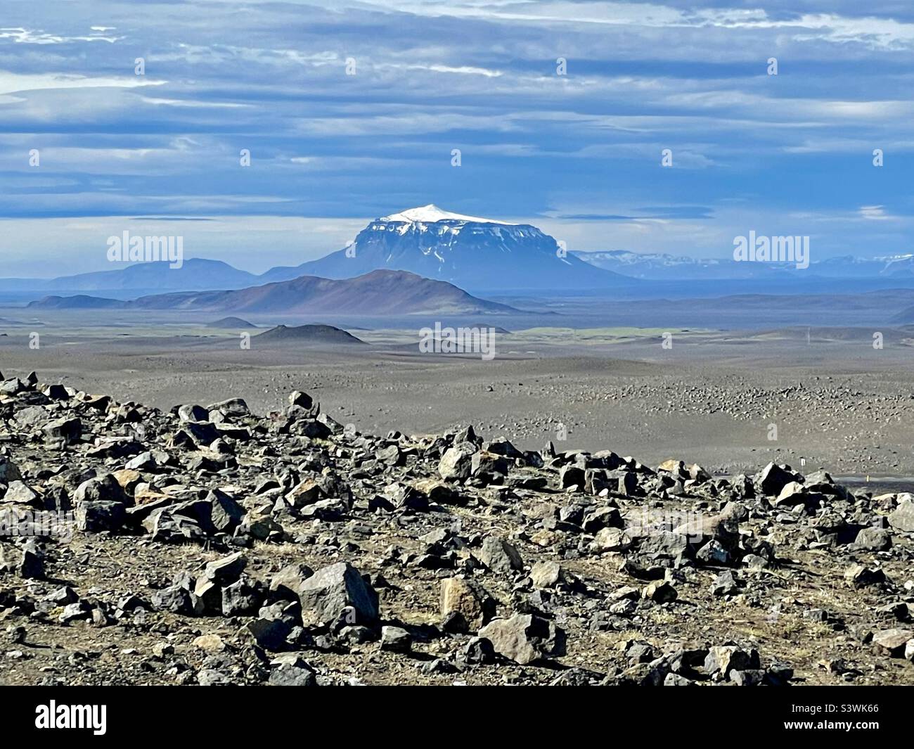 Lava fields of eastern Iceland with snow capped volcano in the distance Stock Photo