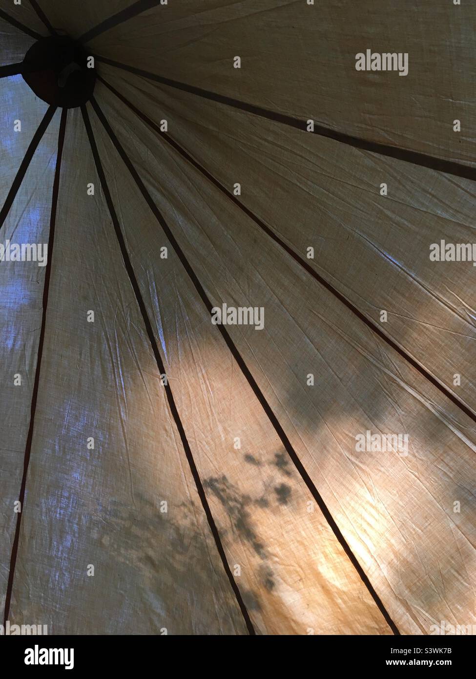 Looking up at dappled sunlight on an old canvas tent Stock Photo