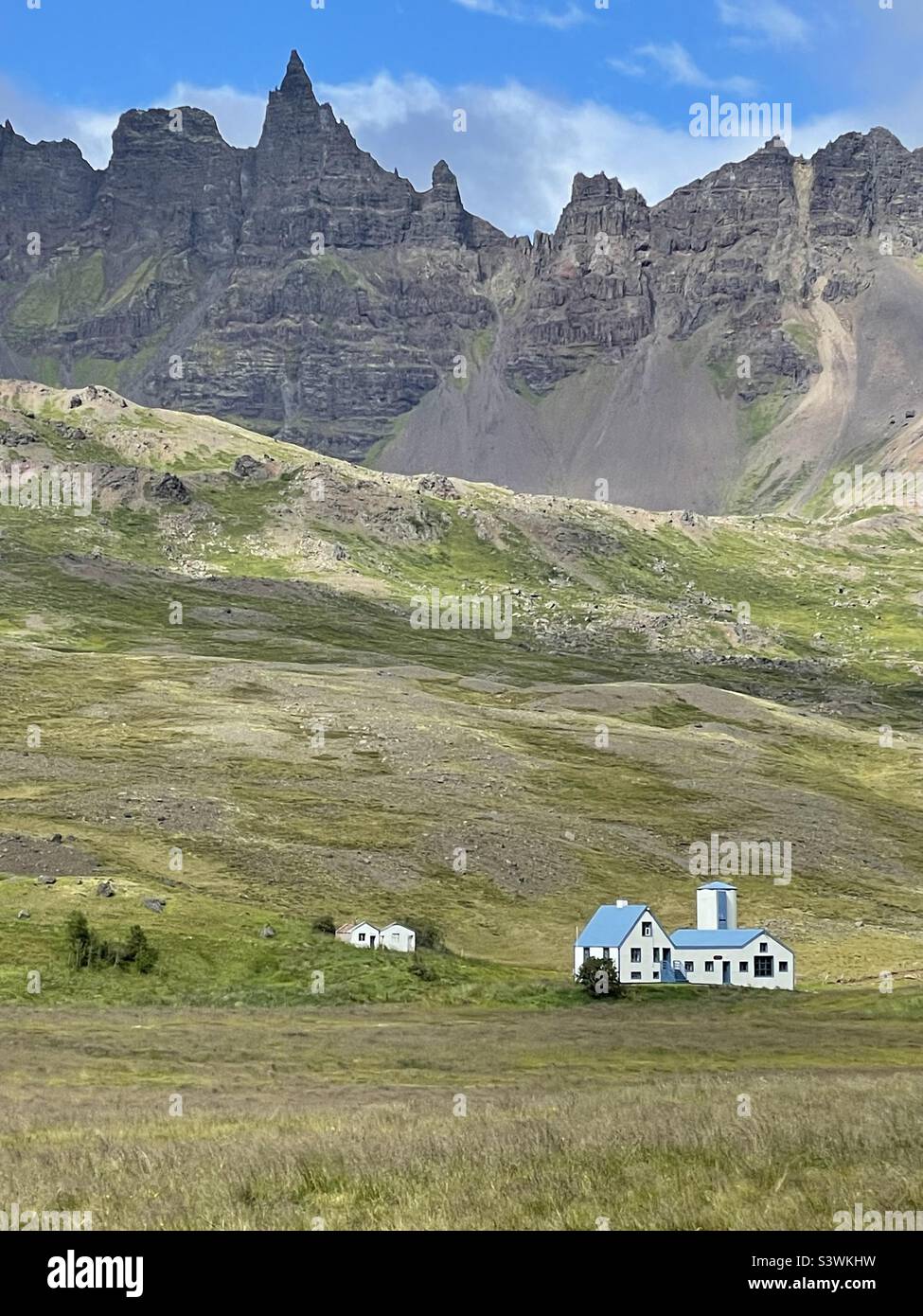 Farmland and pristine farm sitting beneath a towering mountain in northern Iceland - Smartphone Captured Stock Image