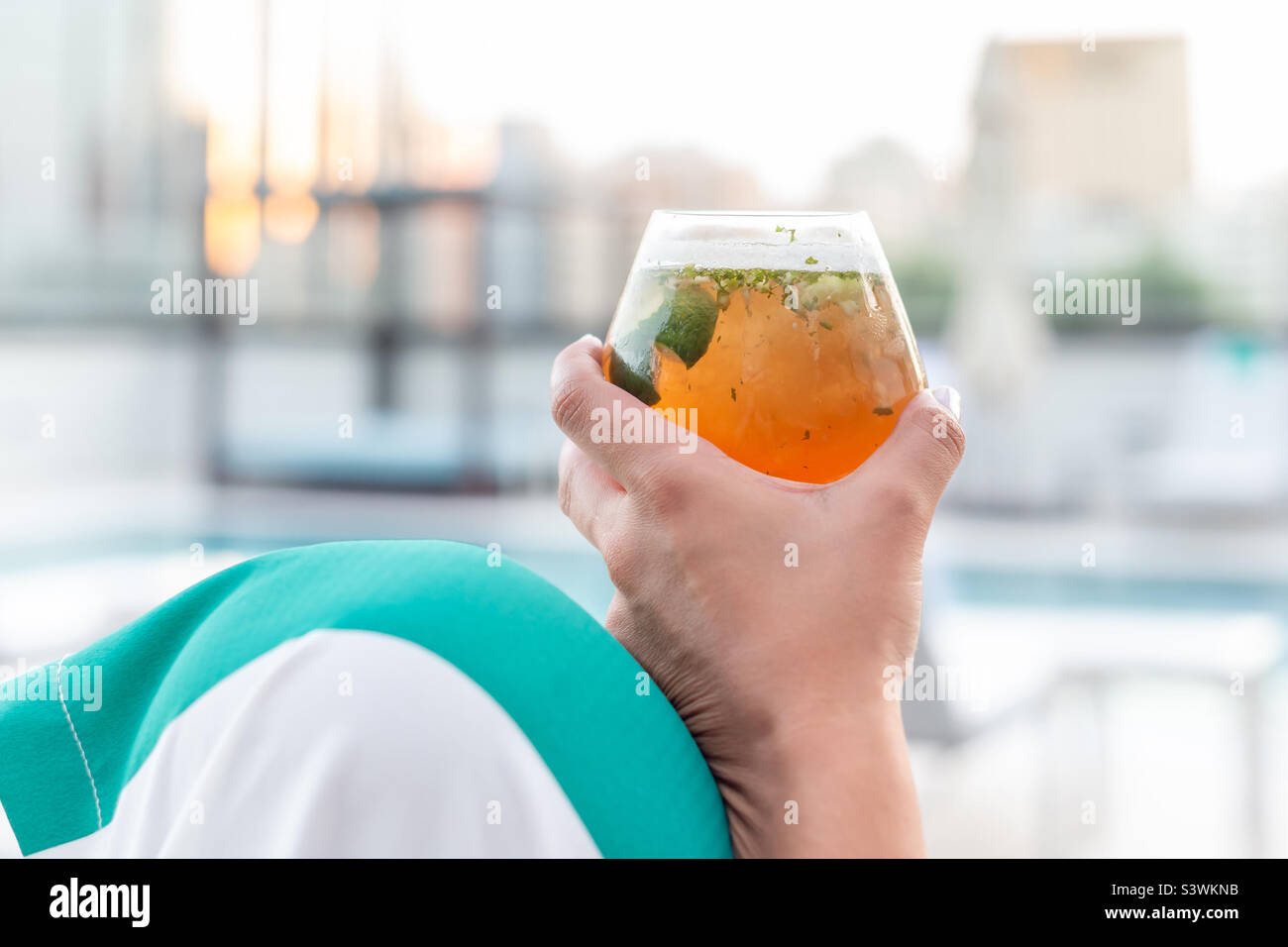 Delicious cocktail in hand, happy hour time at the pool Stock Photo