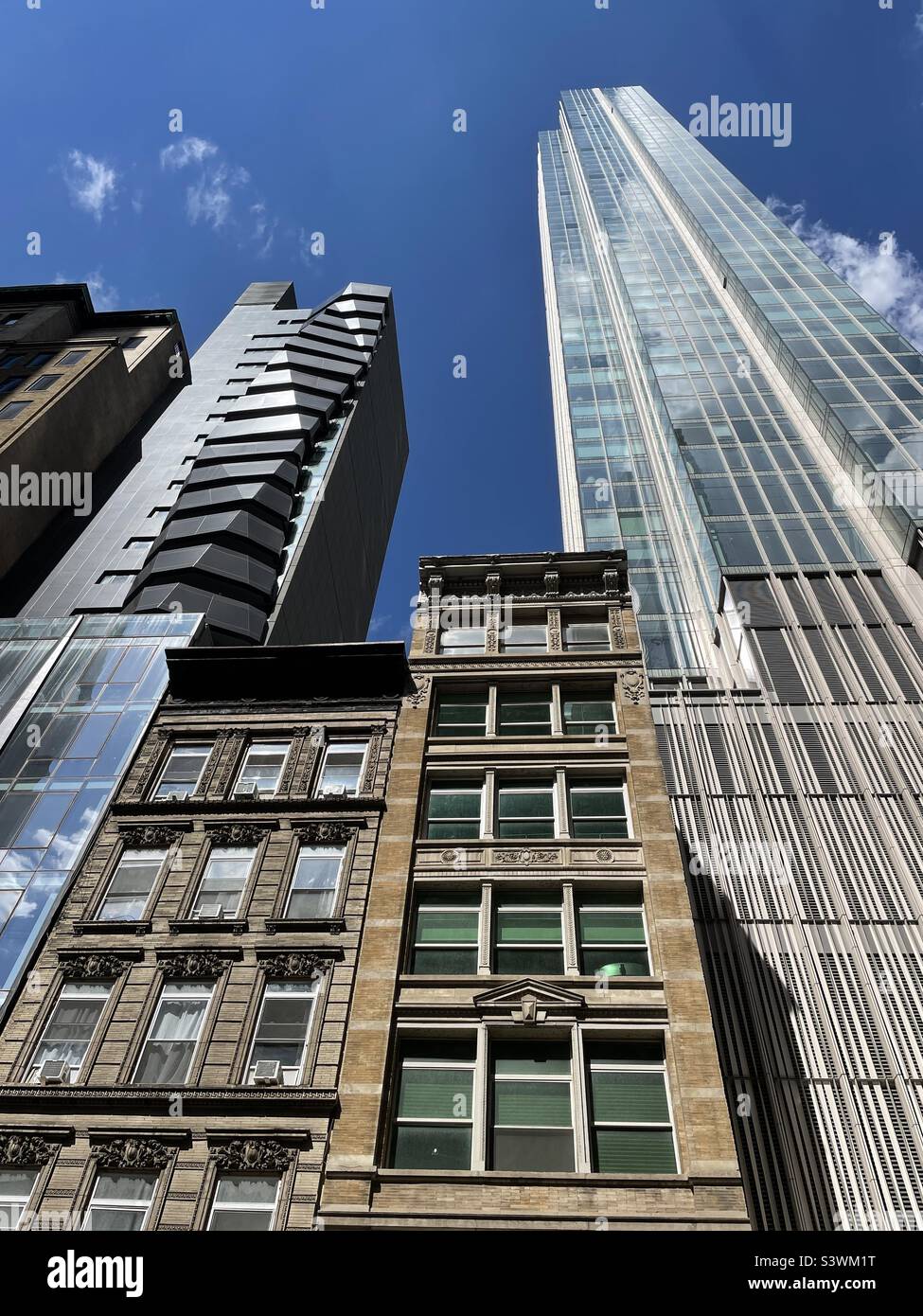Contrasting architecture of foter brownstones and modern high-rise condominiums in the nomad area of New York City, 2022, USA - Smartphone Captured Stock Image