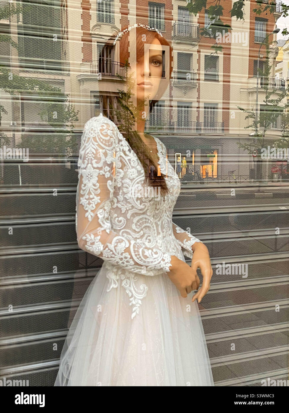 Mannequin wearing wedding dress in a shop window. - Smartphone Captured Stock Image
