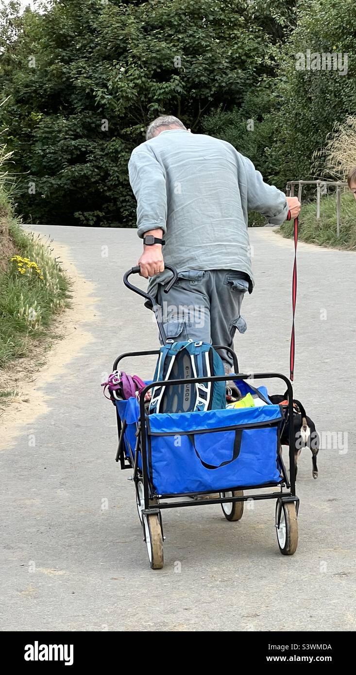 Man dragging a trolley up a steep slope Stock Photo