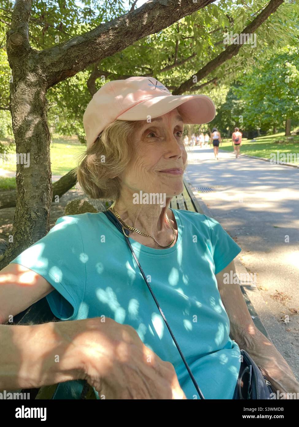 Smiling senior woman in a park on a sunny day - Smartphone Captured Stock Image