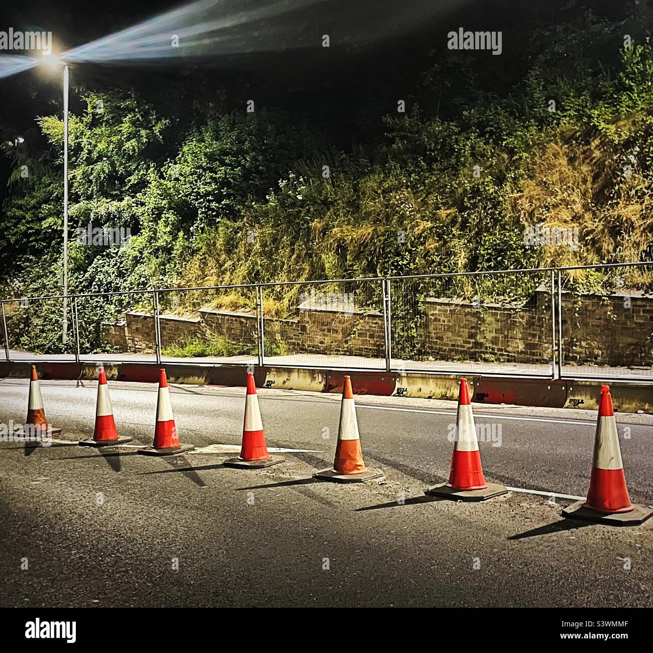‘Running Repairs’ roadwork preparation at night as a lane of the road is coned off Stock Photo