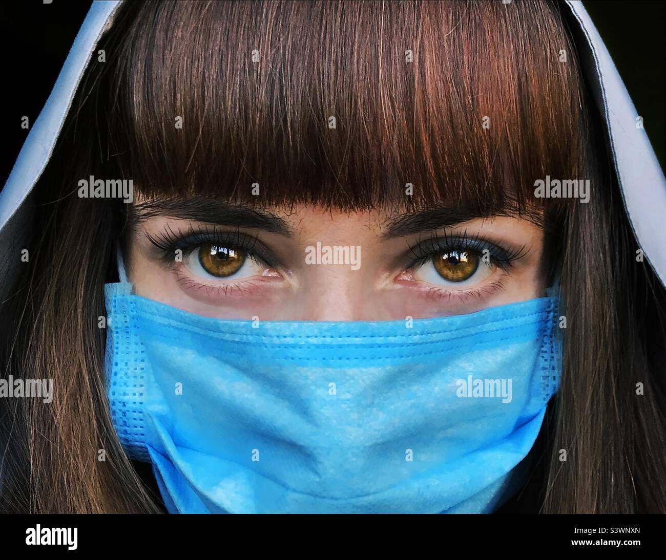 Portrait of a young woman in blue medical mask - Smartphone Captured Stock Image