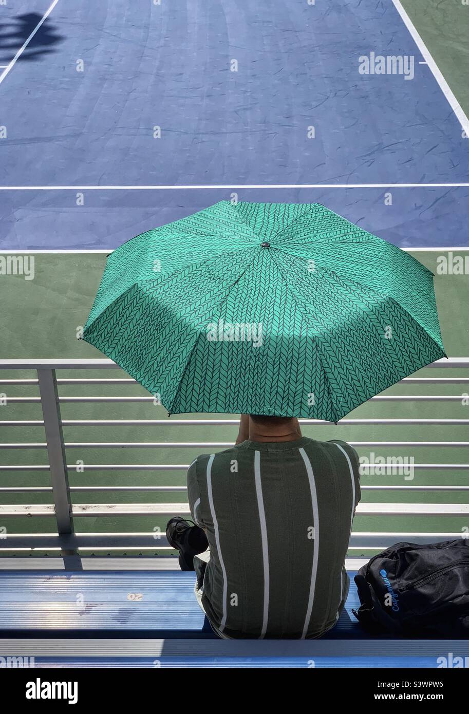 A man holding an umbrella watching US open 2022 Stock Photo