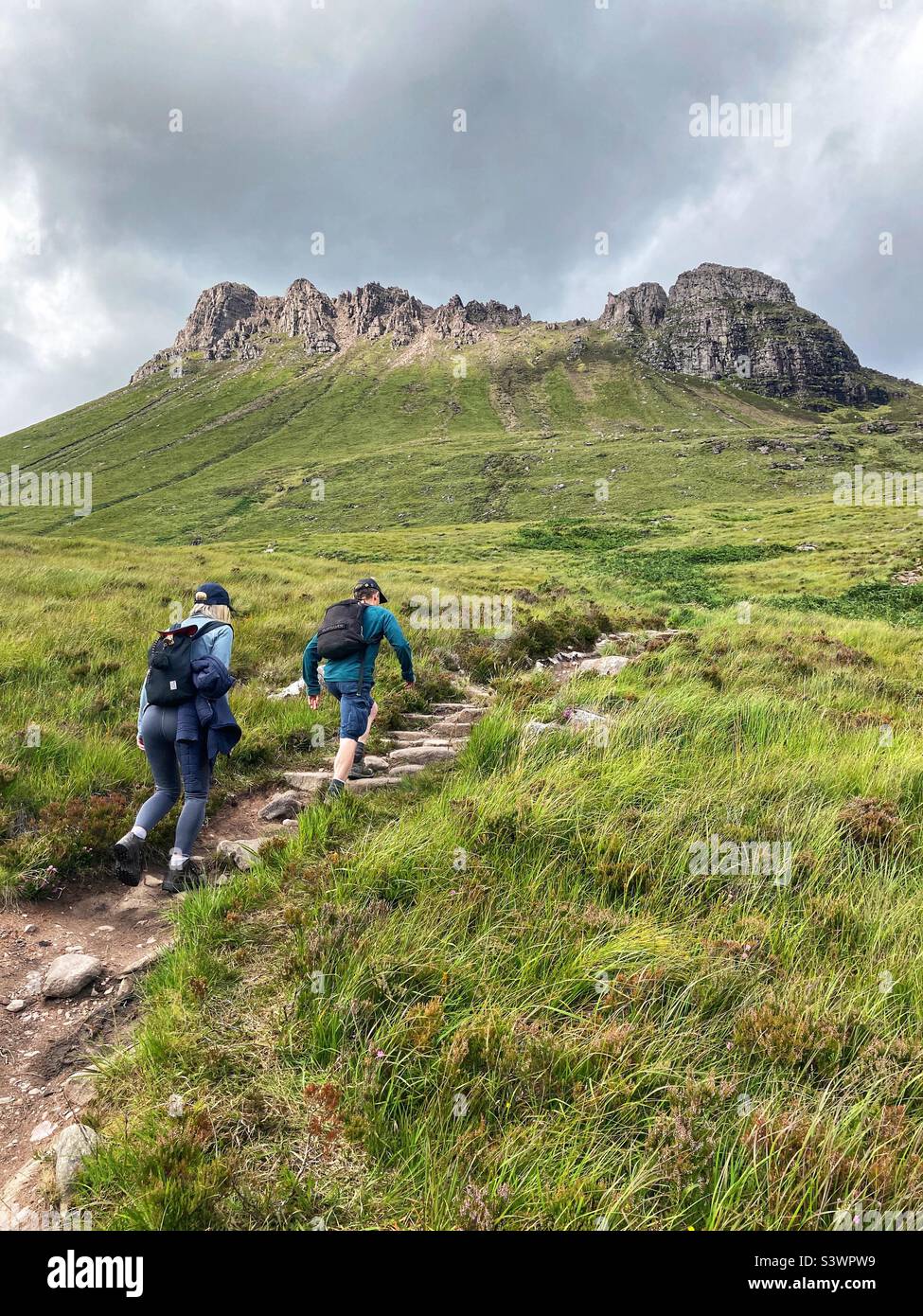 Walkers on the path approach to Stac Pollaidh or Stack Polly, viewed from the south, mountain in Inverpolly, North West Scotland - Smartphone Captured Stock Image