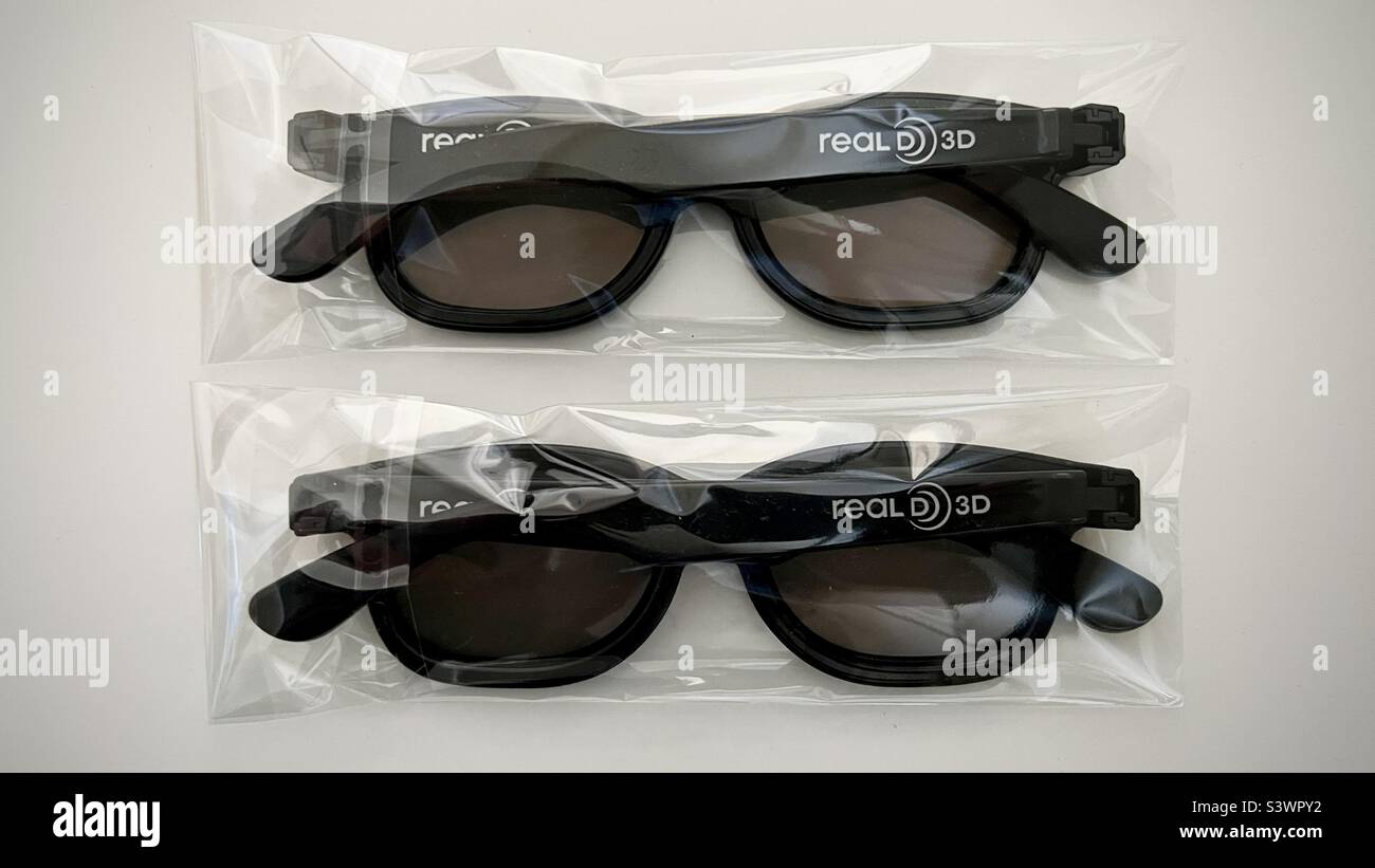 LOS ANGELES, CA, JUN 2022: Two pairs of black, polarized glasses in clear plastic packaging, for 3D films or television, branded with RealD 3D logo Stock Photo