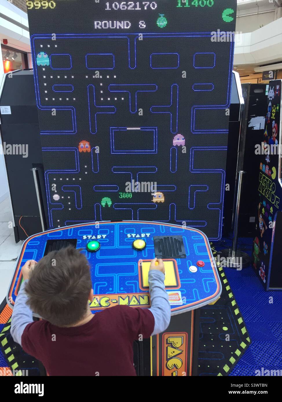 Boy playing giant Pac-Man Stock Photo