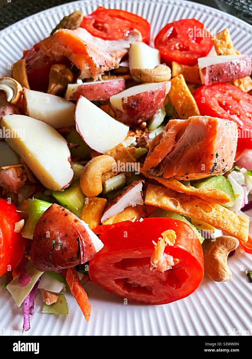 Close-up of a gourmet salmon and new potato salad featuring heirloom tomatoes, 2022, USA Stock Photo