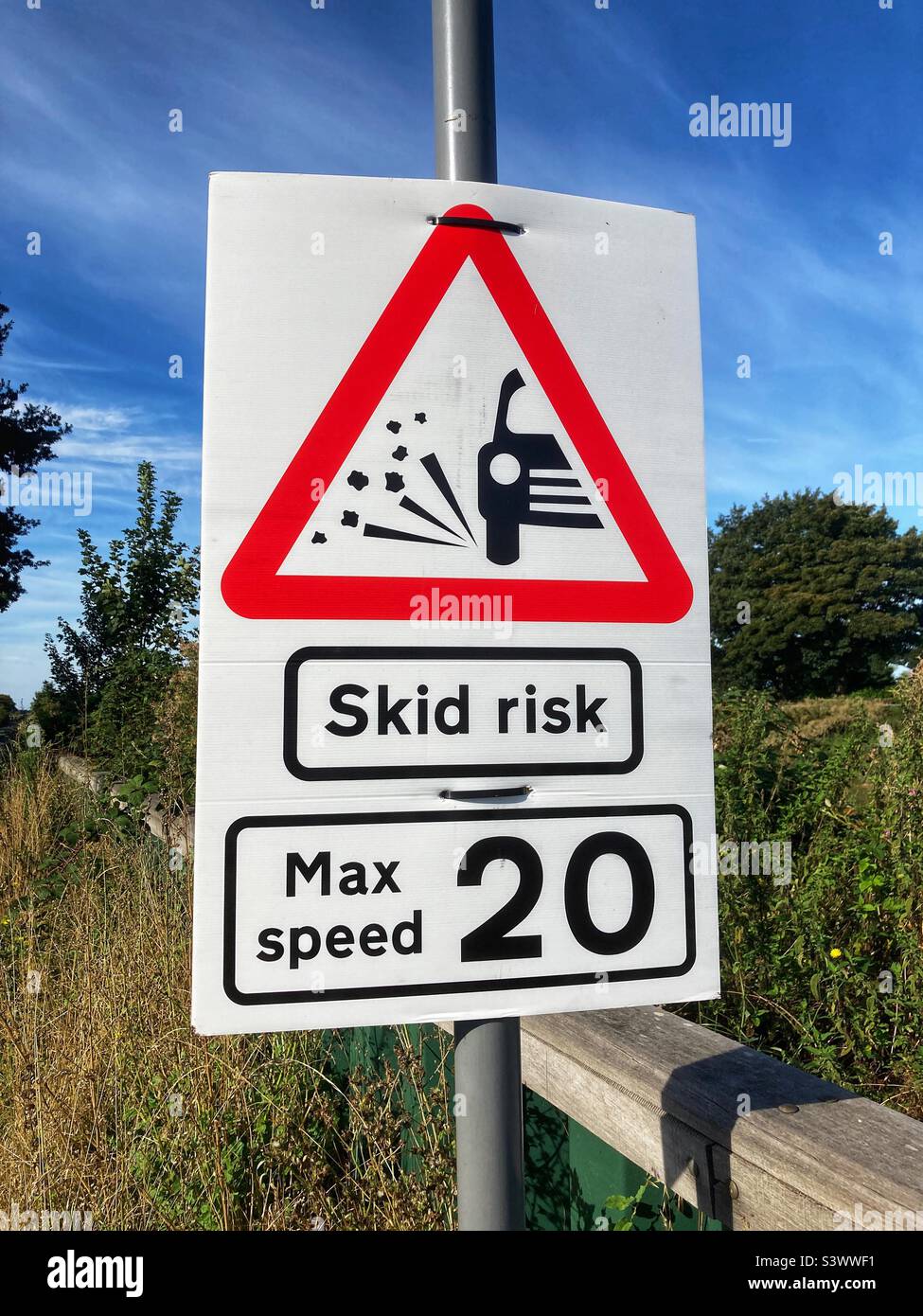 Stone chippings skid risk max speed 20 warning road sign Stock Photo