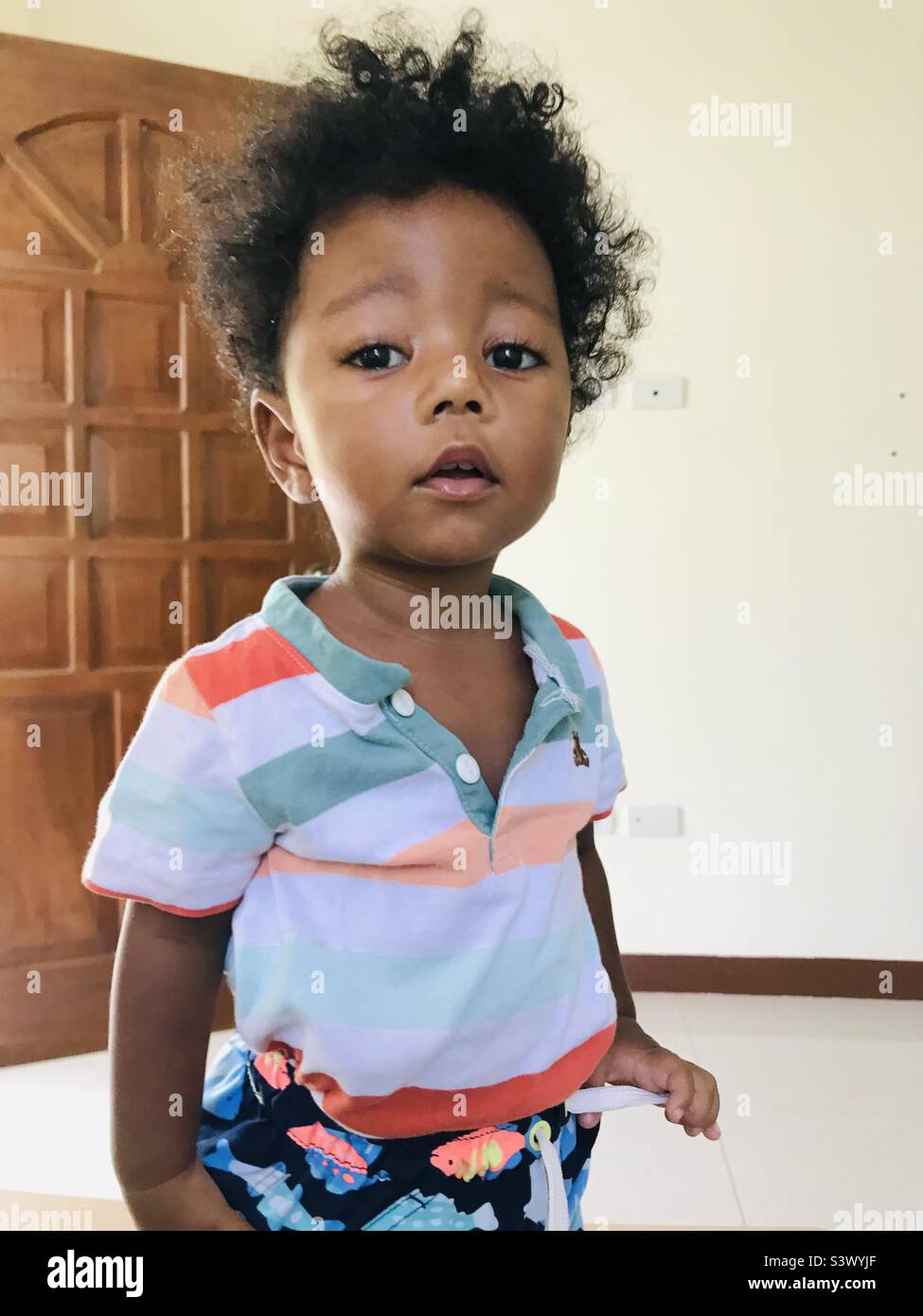 Filipino mixed race, mestizo, African American toddler with colorful shirt posing for the camera Stock Photo