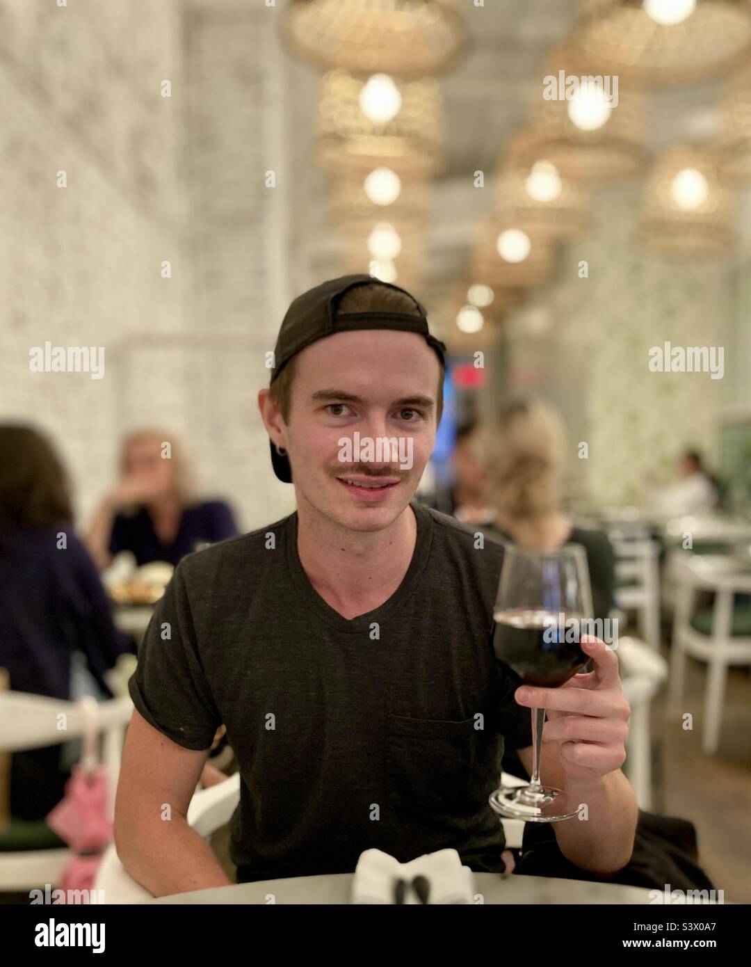 Portrait of a young man holding a glass of red wine. Stock Photo
