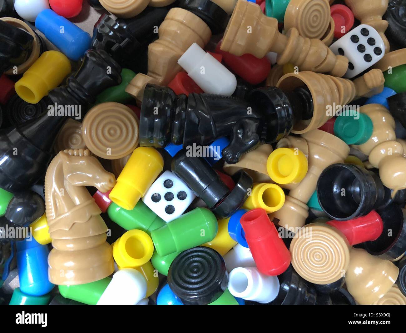 Miscellaneous game pieces, of chess, checkers  (draughts)and solitaire with dice. Stock Photo