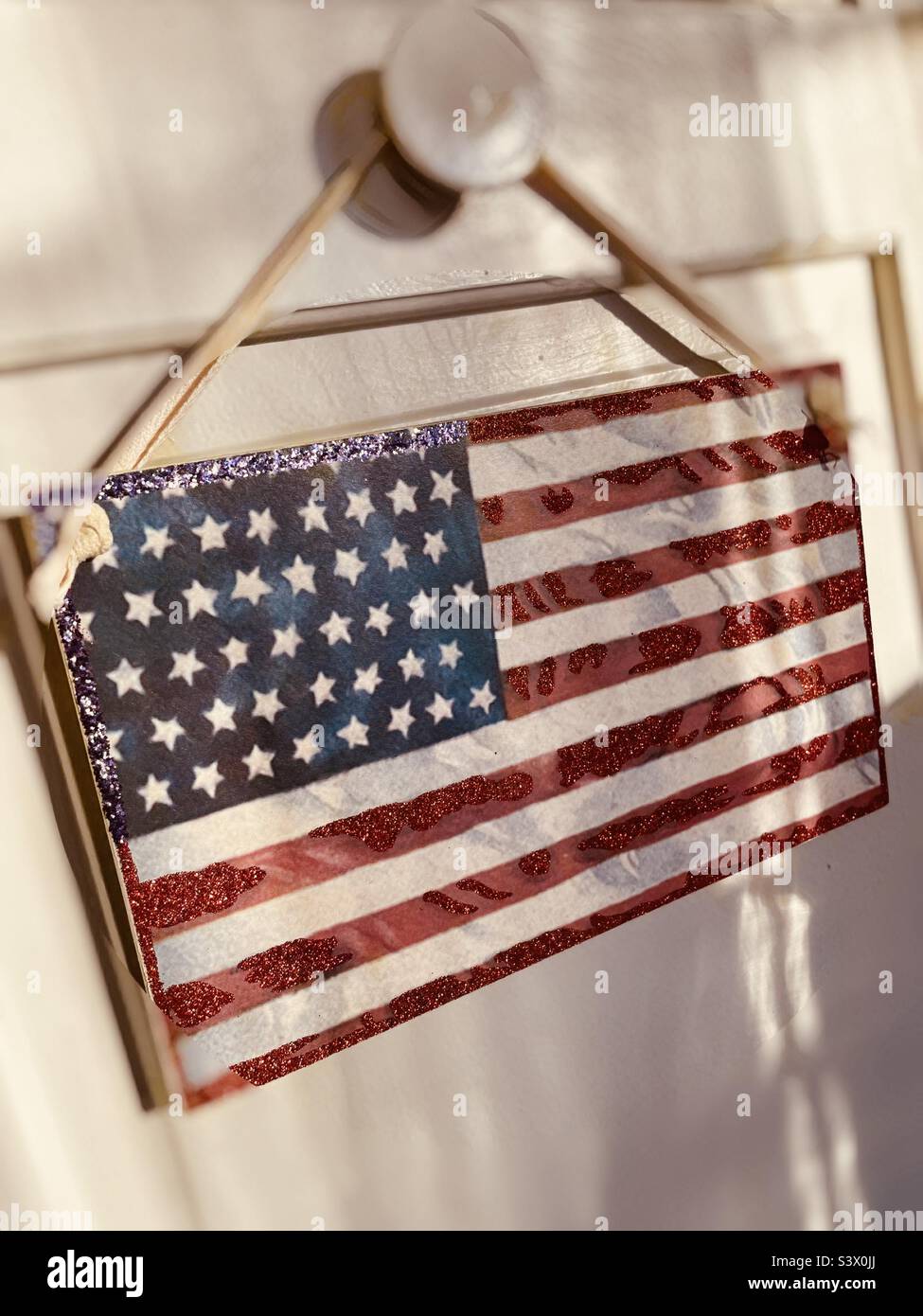 American flag plaque displayed on a door knob in an apartment, 2022, USA Stock Photo