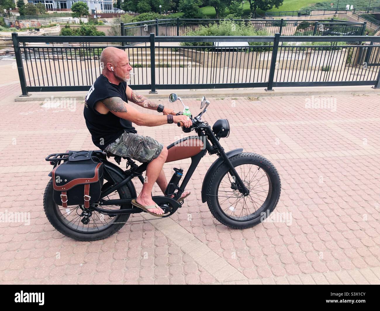 A man cruising on a an electric motorcycle by the river in Denver Colorado - Smartphone Captured Stock Image