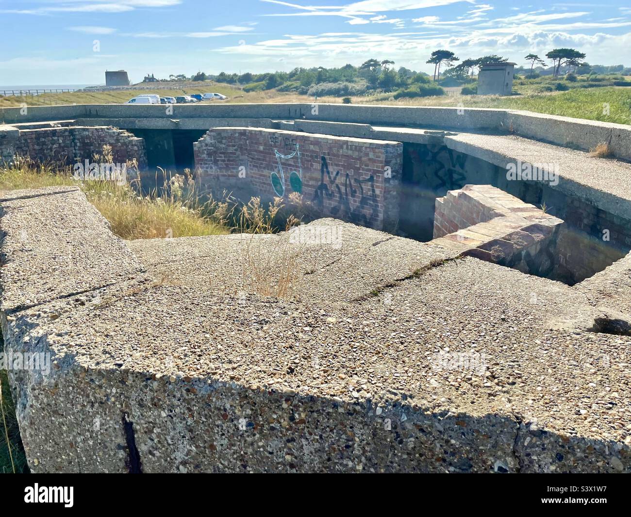 World War 2 bunker with Martello Tower and Observation Tower in background - East Lane, Bawdsey, Suffolk Coast, England, UK. Stock Photo