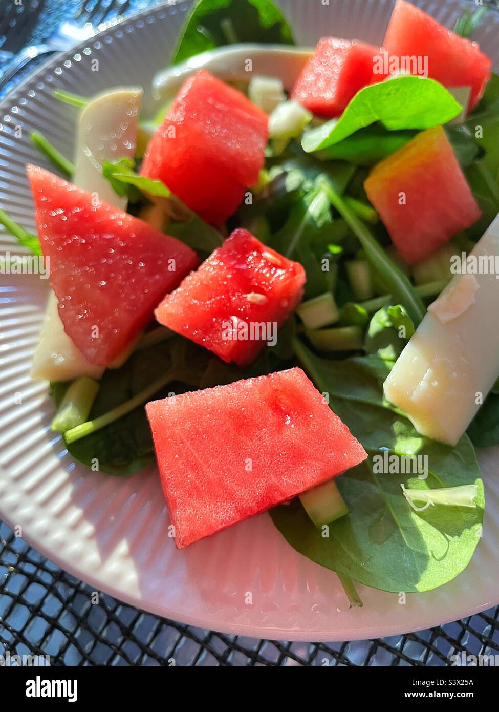 Close up of a summer salad of spinach topped with red watermelon chunks, heart of palm and mini croutons, 2022, USA Stock Photo