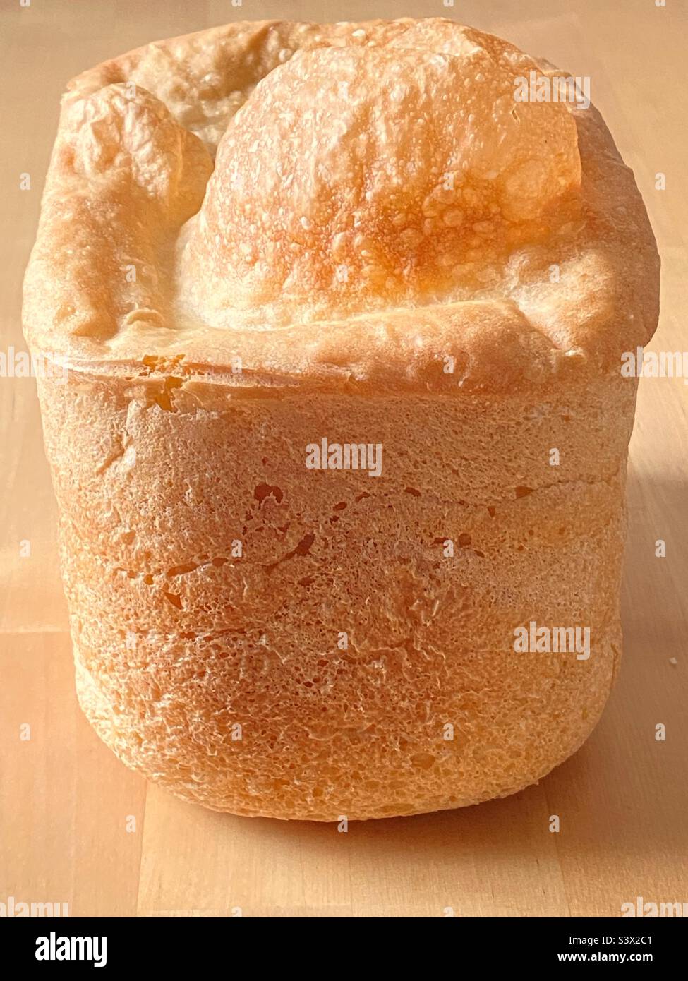 Still life image of a home made domestic loaf of baked white bread on a natural wooden table - Smartphone Captured Stock Image