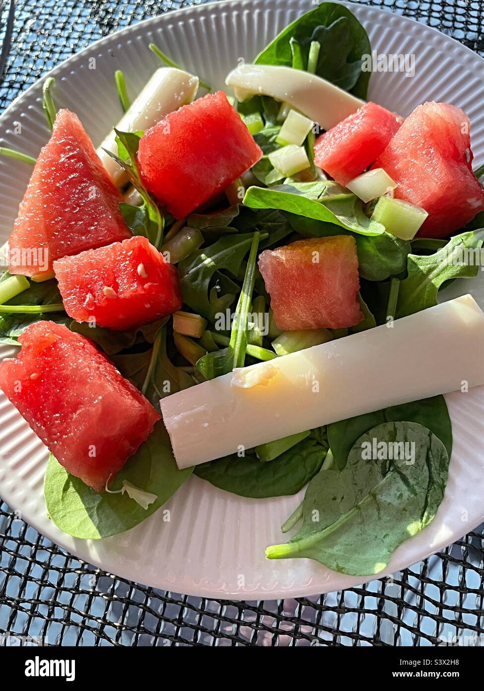 Close-up of a festive summertime salad of red watermelon chunks, hearts of palm and mini croutons on a bed of lettuce, 2022, USA Stock Photo