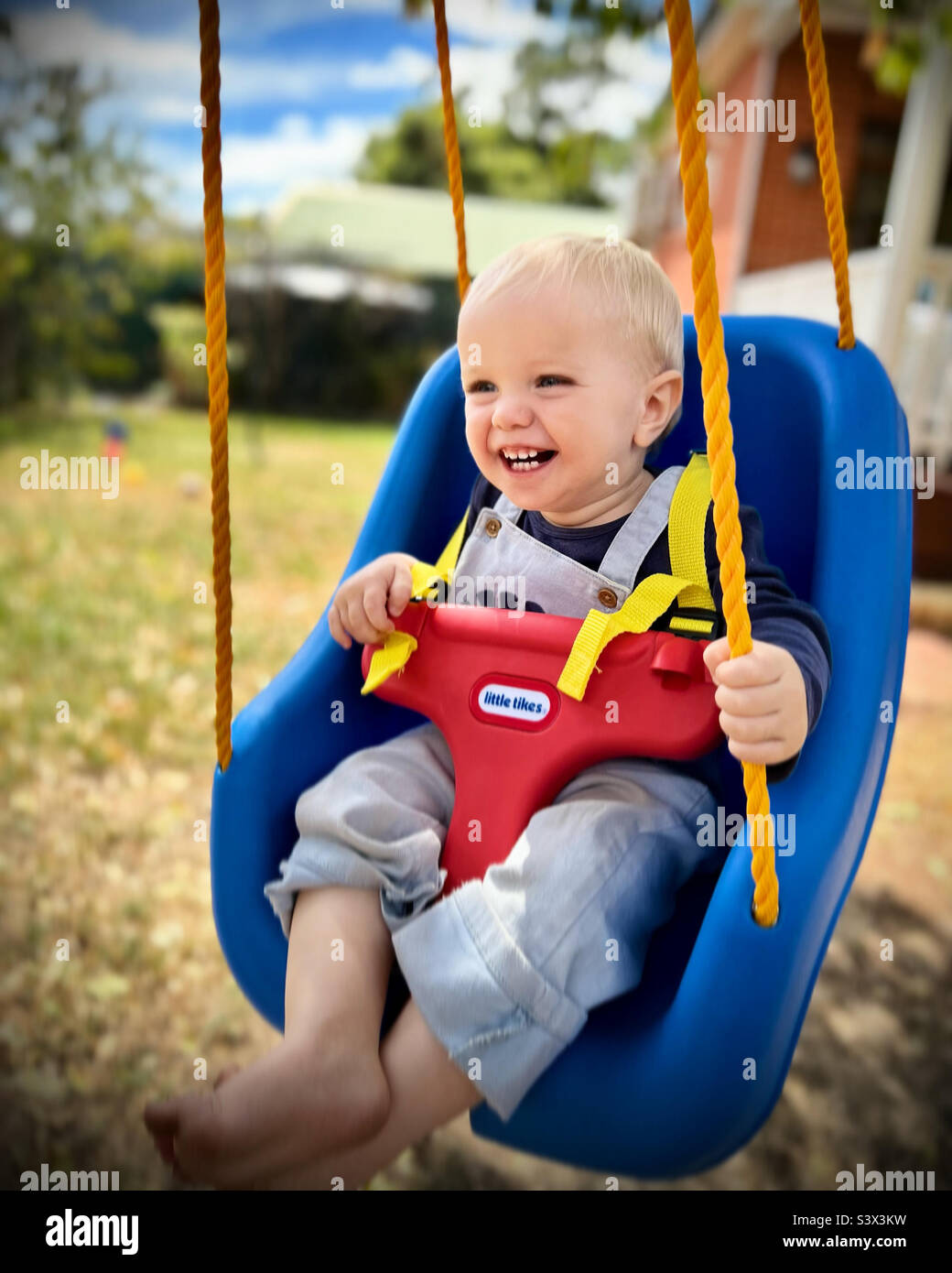 Baby swinging with big toothy grin Stock Photo